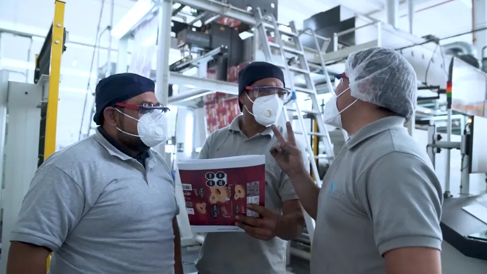 Equipo de Flexo1 revisando una muestra impresa en planta